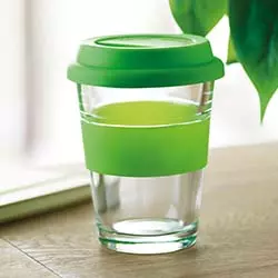 bicchiere in vetro con tappo in gomma di colore verde su scrivania in legno