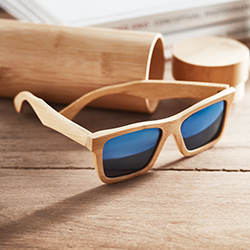 occhiali da sole ecologici in bamboo posati su scrivania in legno