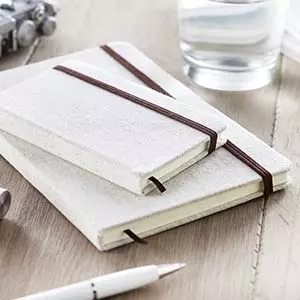 quaderni con elastico in canvas naturale e elastico marrone su scrivania