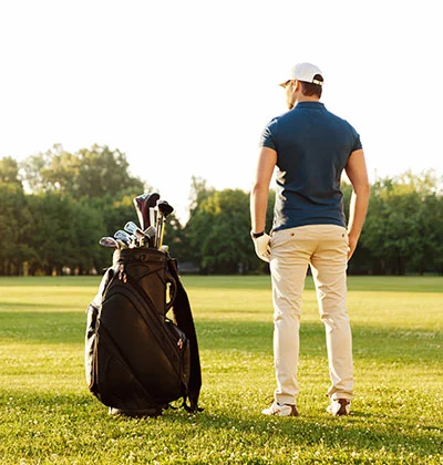 uomo con sacca da golf in un campo da golf