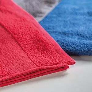 asciugamani in spugna rosso e blu posati su scrivania
