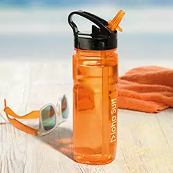 borracce plastica piena d'acqua al mare in spiaggia con occhiali da sole e telo arancione sullo sfondo