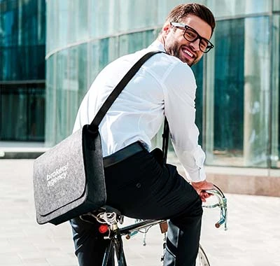 borse da lavoro personalizzate indossate da ragazzon con occhiali in bicicletta al lavoro