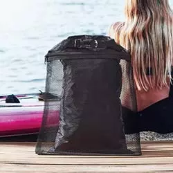 borse impermeabili nere in spiaggia appoggiata sulla sabbia con ragazza bionda e tavola d asurf