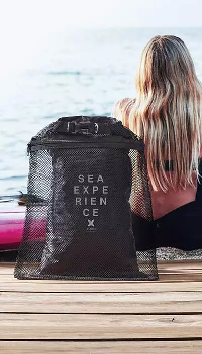 borse personalizzabili con logo o iniziali per il mare idrorepellenti portate da ragazza bionda seduta di spalle su una barca