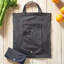 borsa personalizzabile spesa in tessuto resistente di colore grigio con tasca aggiuntiva su piano in legno con frutta e verdura