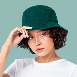 cappello pescatore verde indossato da ragazza set fondo colorato azzurro