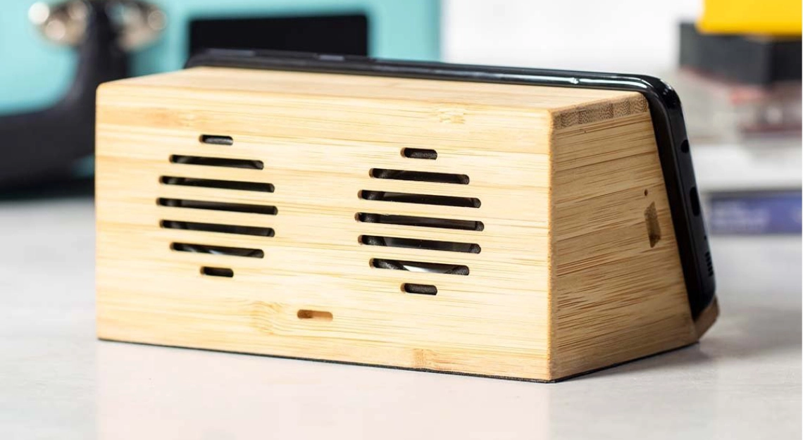 cassa wireless in legno su scrivania con oggetti sullo sfondo