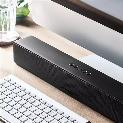 sound bar su scrivania in legno con computer affianco