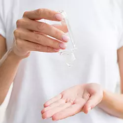 Primo piano su mani di donna che utilizza gel igienizzante mani