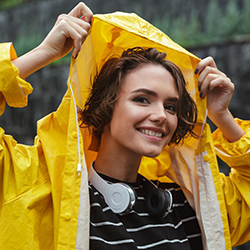 ragazza sorridente che indossa impermeabile personalizzato trasparente per abbigliamento personalizzato