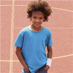 bambino sorridente su campo sportivo con maglietta fruit of the loom azzurra