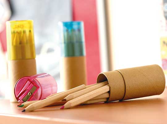 matite da disegno con portamatite in cartone e temperino in plastica colorato su tavolo in legno