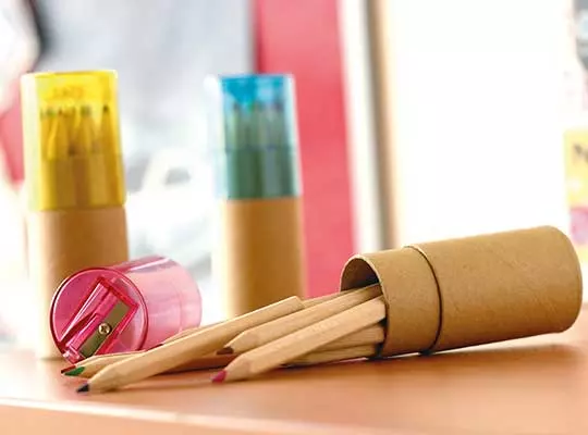 matite da disegno con portamatite in cartone e temperino in plastica colorato su tavolo in legno