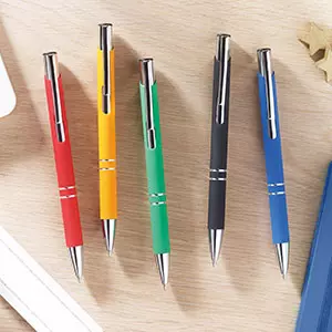 Penne a sfera di colori assortiti appoggiate su scrivania in legno