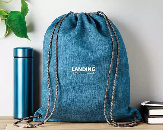 personalizzazione zaini a sacca con logo brand aziendale associato a borraccia termica blu cobalto su scrivania vista forntale
