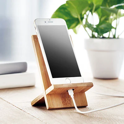 Portacellulare da tavolo in legno con smartphone in carica appoggiato su scrivania