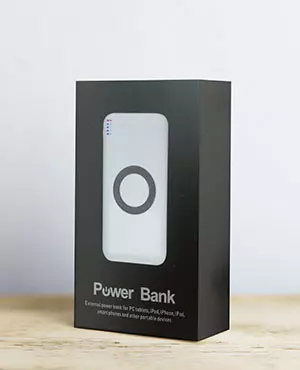 power bank personalizzato in elegante confezione regalo poggiato su tavolo in legno power bank personalizzato in elegante confezione regalo poggiato su tavolo in legno