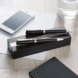 set di penne personalizzate eleganti appoggiati sul tavolo con occhiali da vista