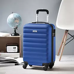 valigie personalizzate incise su targhetta frontale con sedia bianca, mappamondo, radio e riviste